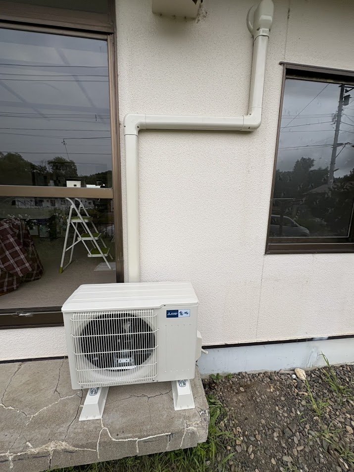 施工後：FFストーブ排気筒を避けたL字配管と三菱室外機の設置完了