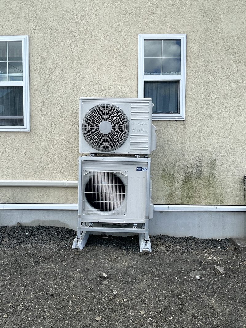 完成：2段架台の上段に2階エアコンの既設室外機、下段に今回入れ替えた室外機が収まっている