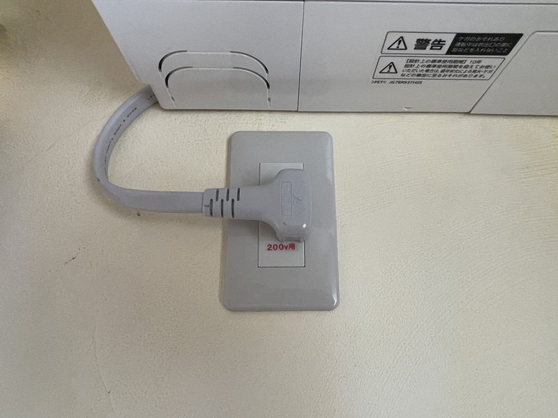 佐呂間町の施工例：壁の中に埋まっていた200V電源を、抜き差しできる位置に増設したコンセント