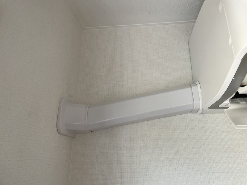 完成：室内機から左へ伸びる冷媒配管の化粧カバー。壁の上部を通してそのまま外壁を貫通させている